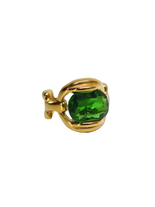 A gold-colored band ring with a large green emerald-like stone set in the center.