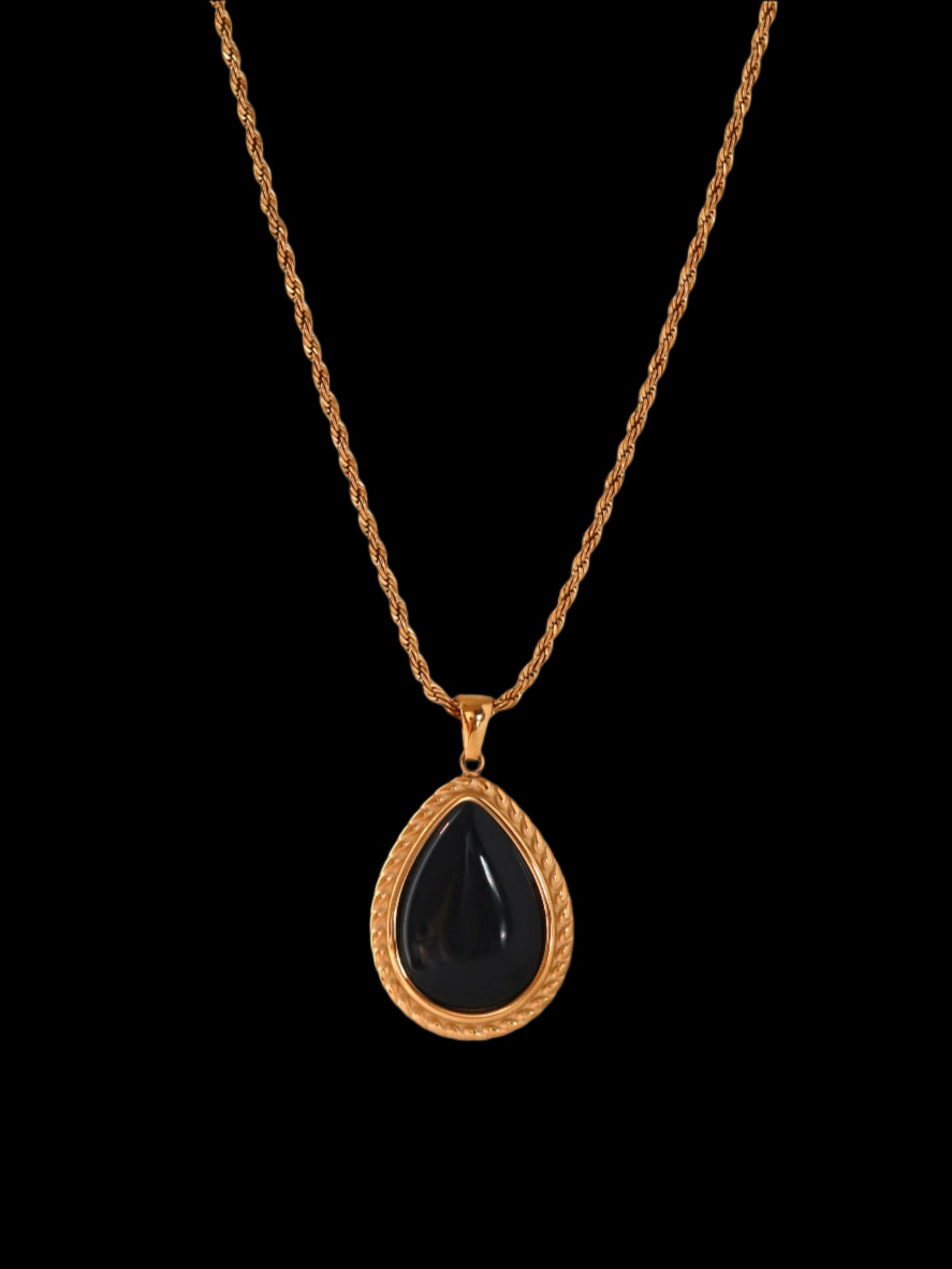 Necklace with a black teardrop pendant on a gold chain against a white background
