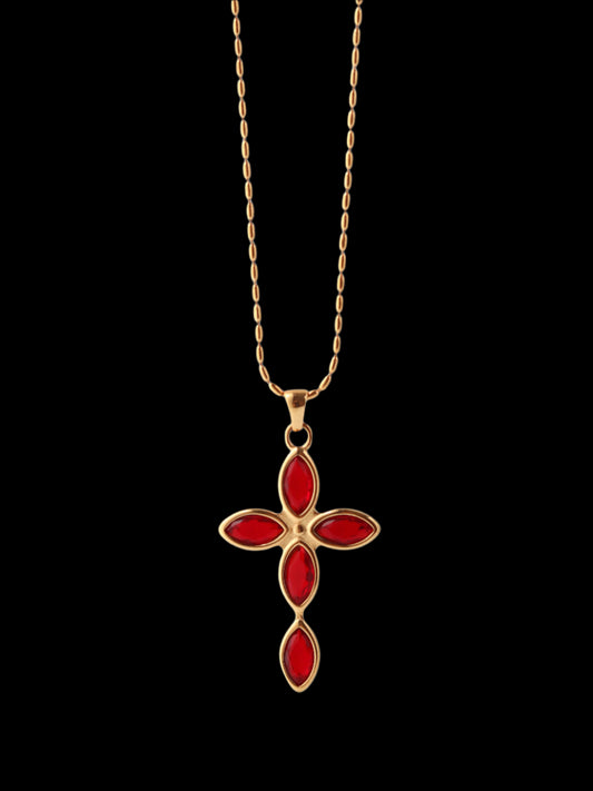 Gold necklace with a red cross pendant on a white background