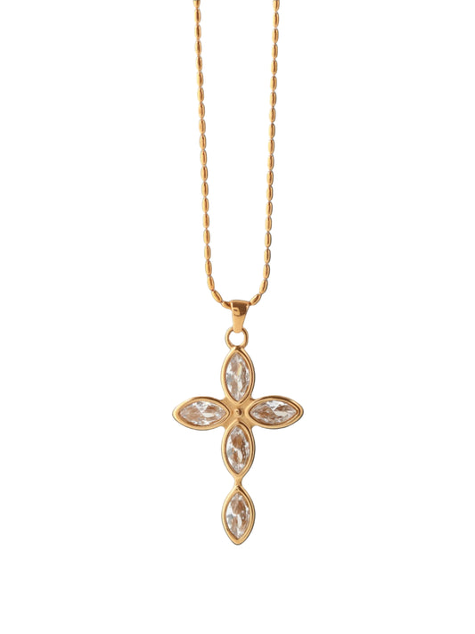 Gold cross necklace with clear stones on a white background