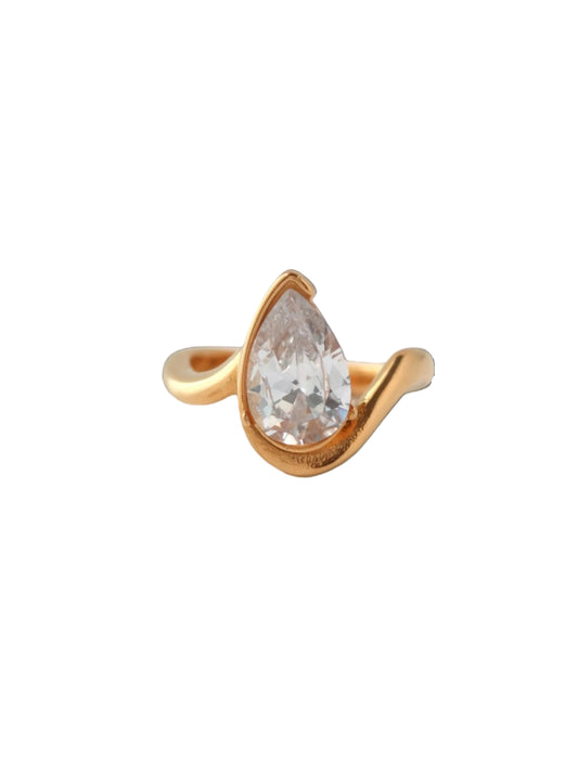 Gold ring with a clear teardrop-shaped gemstone on a light gray background