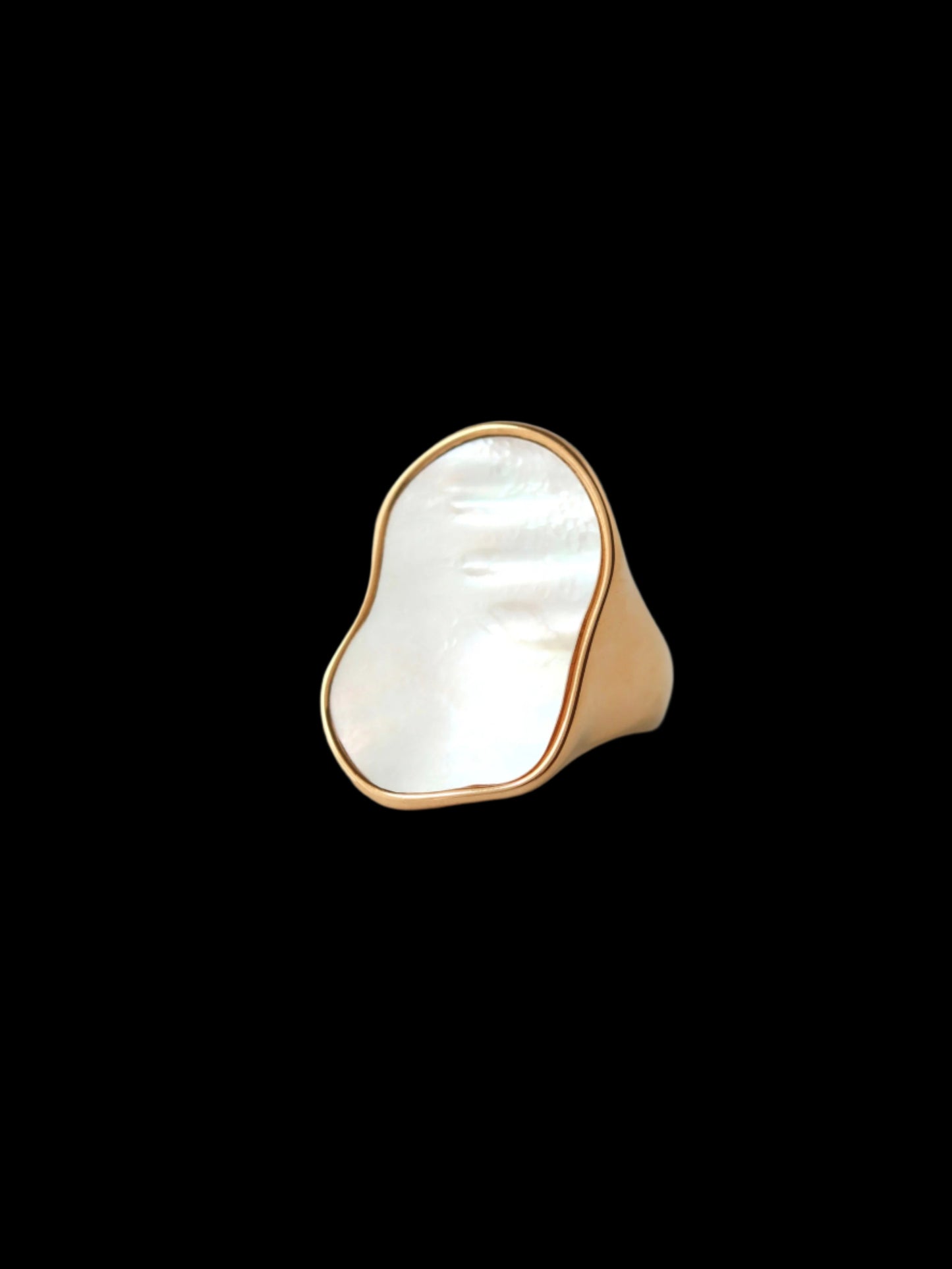 Gold ring with a large white stone on a gray background