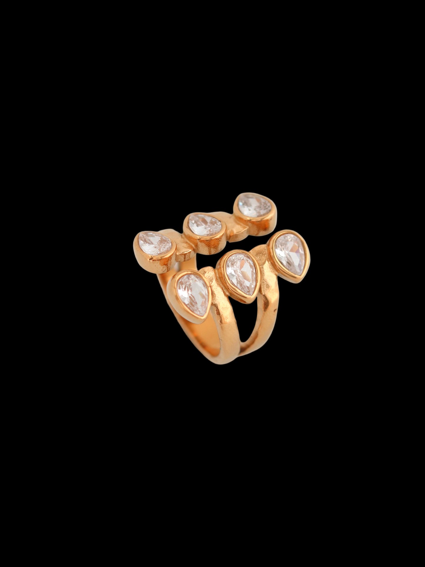 Gold ring with embedded stones on a light gray background