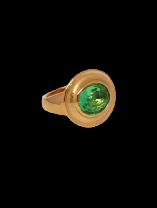 Gold ring with a green gemstone on a black background