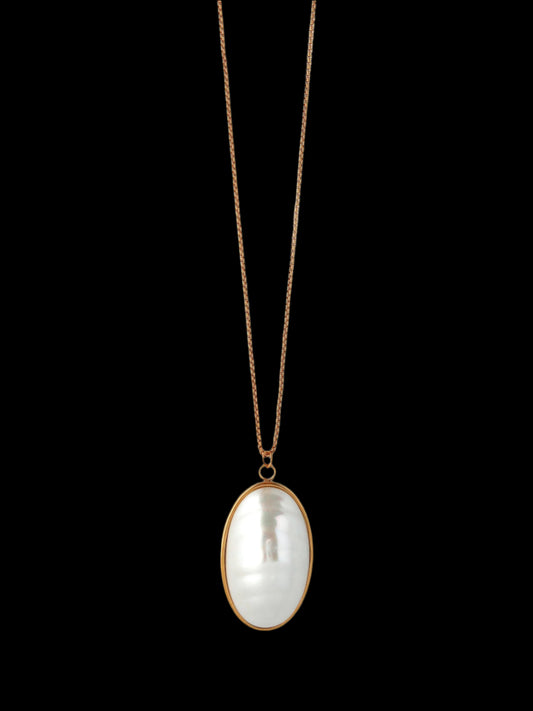 Necklace with a large, oval-shaped pearl pendant on a light gray background