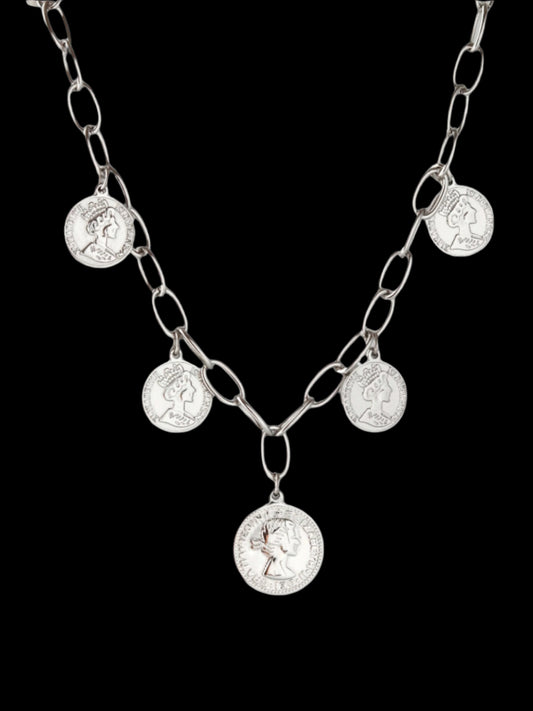 Silver chain necklace with round pendants on a light gray background