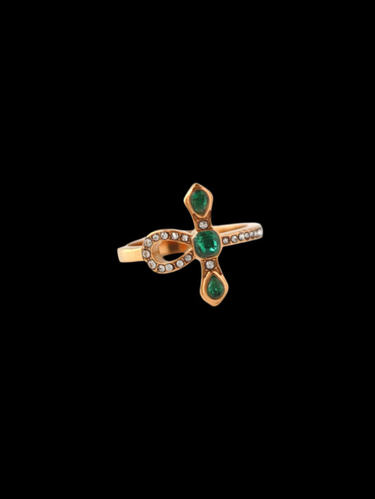 Gold ring with green gemstones on a white background
