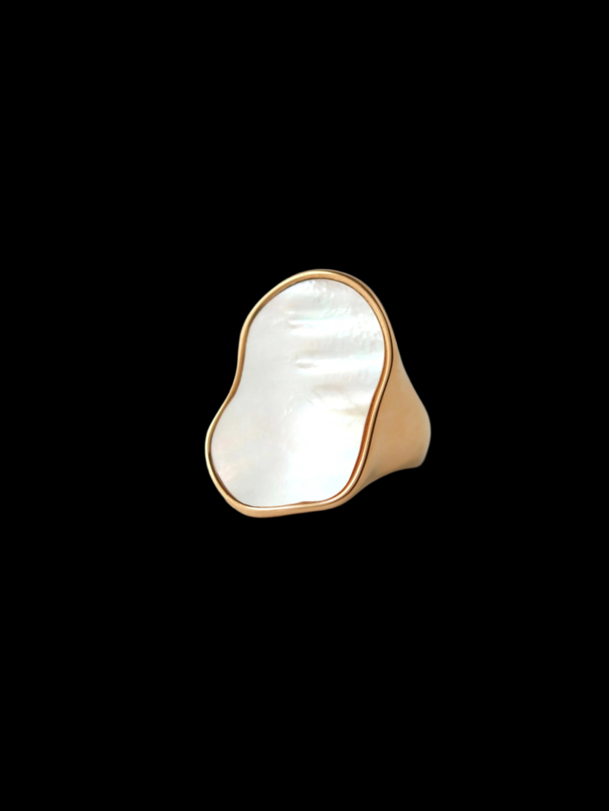Gold ring with a large white stone on a gray background