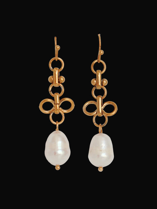 Gold bow-shaped earrings with pearl drops on a light gray background